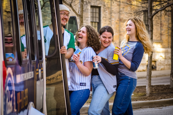 Fans boarding the On Tap Bar & Restaurant free shuttle to American Family Field for a Milwaukee Brewers baseball game.