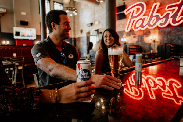 Guests enjoying food and drinks inside On Tap Bar & Restaurant at Brewhouse Inn & Suites.